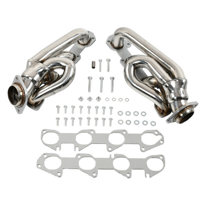 Set of polished exhaust manifolds with gaskets and bolts on a white background